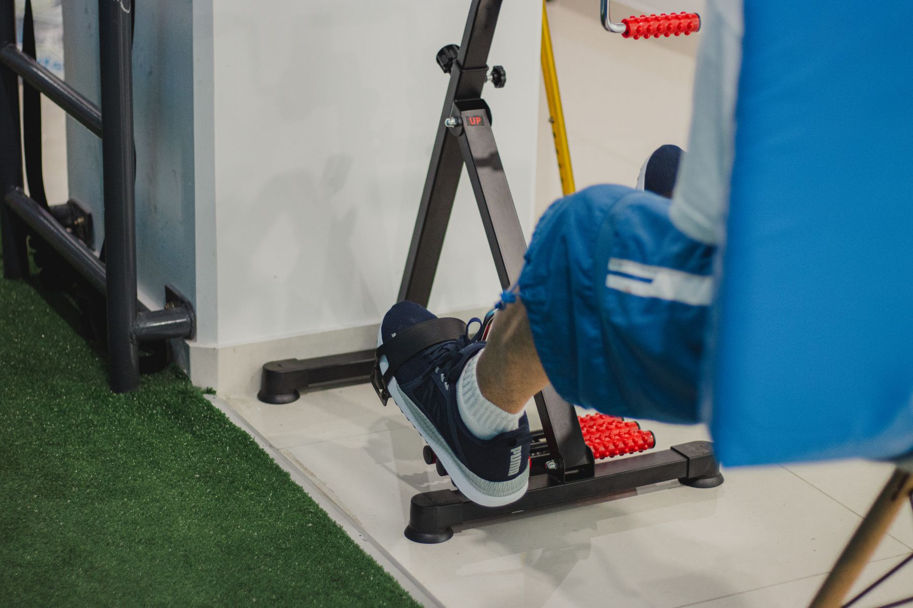 Cyclist on an indoor trainer, side view under hard light