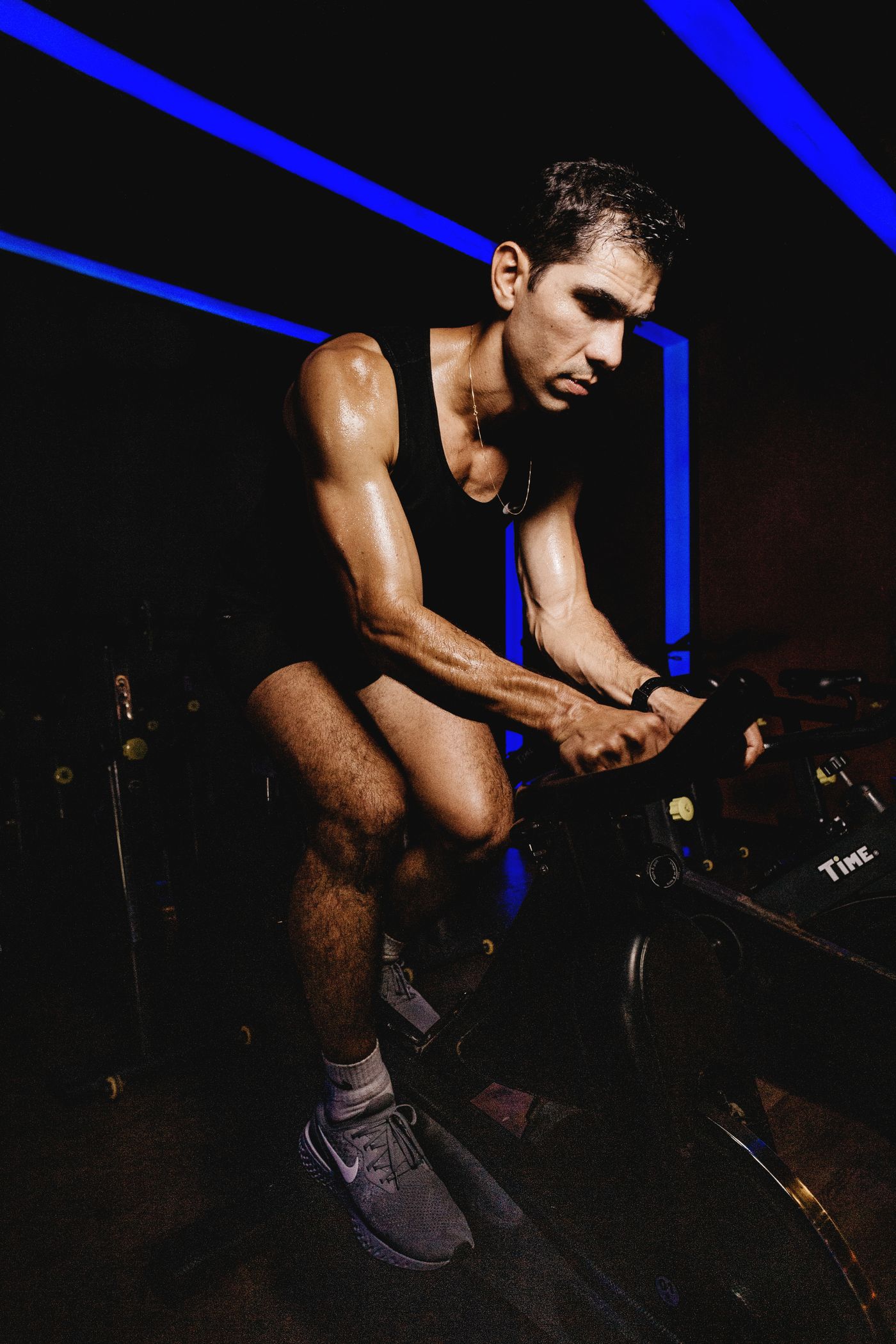 Cyclist working hard on an indoor trainer, seen from the side